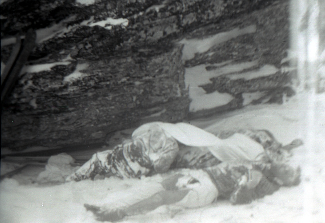 Bodies at the outlier rock. The farthest is Doroshenko; Kolmogorova lies, leaning against Dyatlov (under the sheet); Krivonischenko is in the foreground.