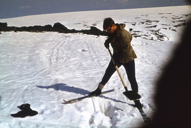 Yuri Kozin digging in the snow near where a piece of clothing was found.