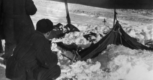 Koptelov (squatting) showing Karelin the tent.