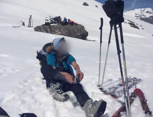 Gabriella taking off her ski boots to massage her feet. Photo by Julia Hruska