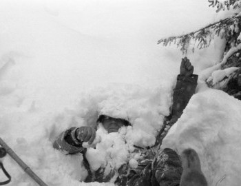 31 Jan 1959 - Auspiya river, Nikolay lies in the snow. The ski that lay next to it is no longer visible covered with snow, next to it there are two ski poles.