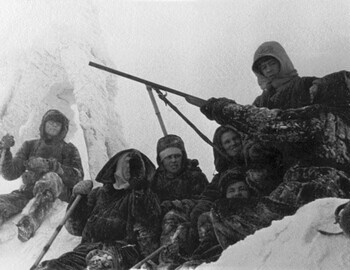 Nikolay Tregubov watching a girl with a firearm. Zina is to his left. Somebody seems to be shielding himself from the rifle. Northern Ural, 1957
