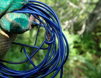 Wire stranded 0.75 mm2 blue insulation, twisted and tied in a knot. At one end it had white oxide, presumably from the battery terminal. Most likely used for flashlights in tents (miner's light bulb)