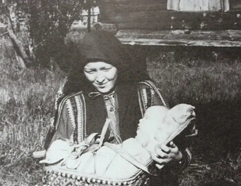 A woman holds an apu (cradle) with a child.