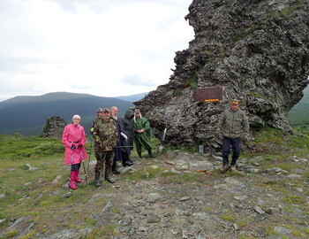 8 July, 2025 - Each  member of the expedition brings his own tangerine to the The Memorial (aka Boot Rock)