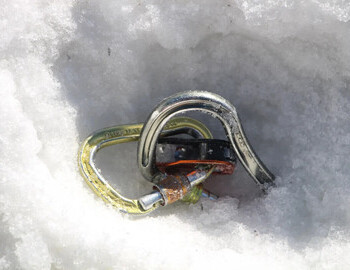 Two weeks after the incident the snow is melting in the sun revealing a carabiner near the cairns..